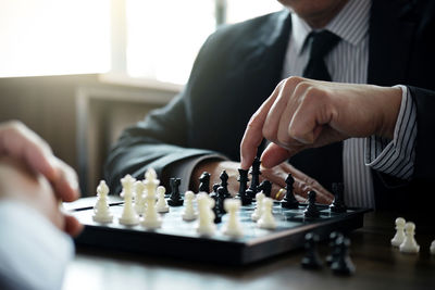 Close-up of business colleagues playing chess in office