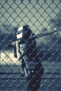 Close-up of person holding chainlink fence