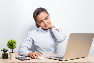 Young woman using mobile phone on table
