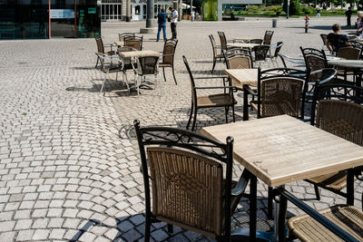 Empty chairs at sidewalk cafe