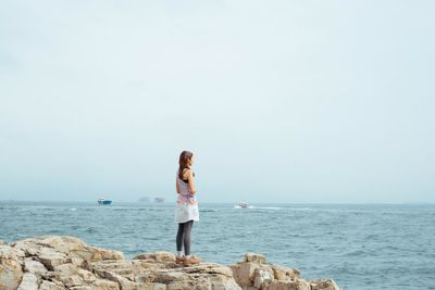 Rear view of woman overlooking calm sea