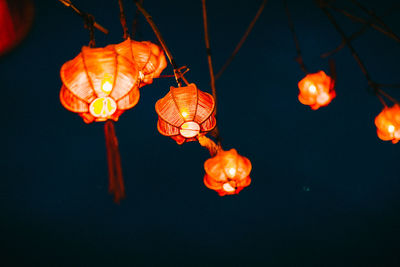 Low angle view of illuminated lanterns hanging at night