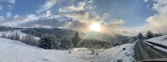 Panoramic view of snow covered landscape against sky