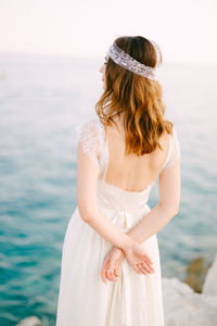 Young woman standing at sea shore