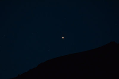 Low angle view of silhouette moon against sky at night