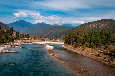 Scenic view of river amidst mountains against sky