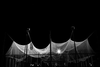 Low angle view of illuminated tent against clear sky at night