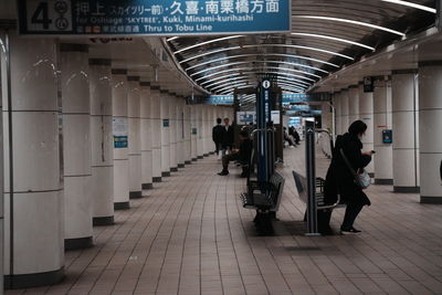 Rear view of people walking in subway