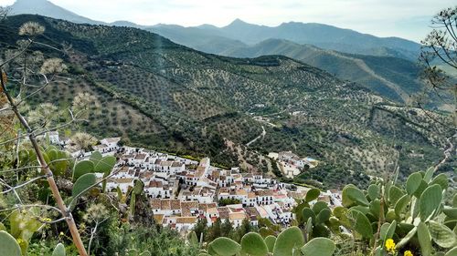 High angle view of town by mountains against sky