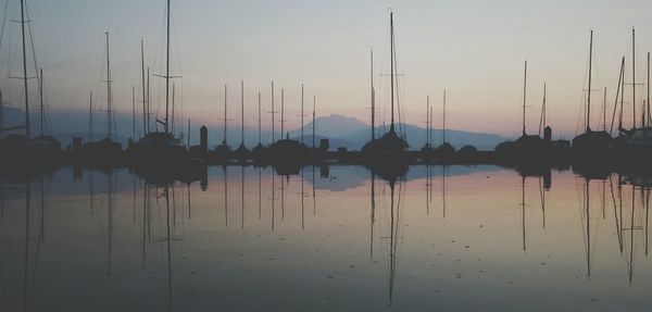 Boats in harbor at sunset