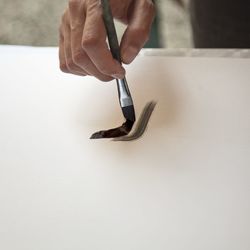 Close-up of hand holding ring on table