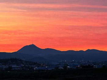 Scenic view of silhouette mountains against romantic sky at sunset