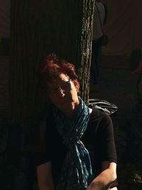 Close-up of woman with tree trunk