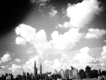 Low angle view of modern buildings against cloudy sky