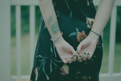 Midsection of woman standing by railing