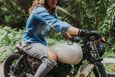 Side view of woman sitting on motor cycle