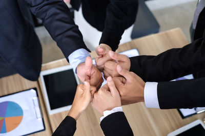 High angle view of colleagues gesturing thumbs up sign over desk
