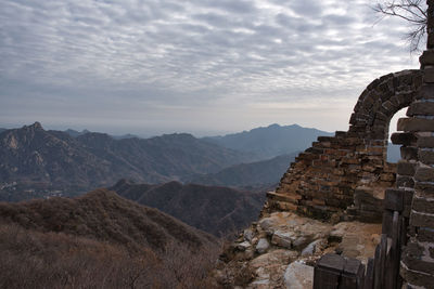 Scenic view of mountain range against cloudy sky