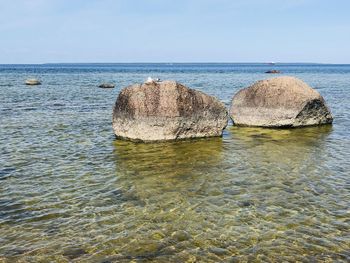 Rocks in sea against clear sky