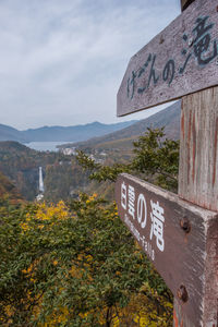 Information sign on mountain against sky