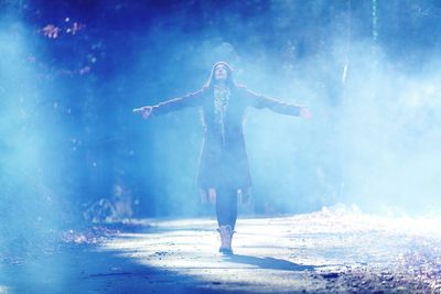 Full length rear view of woman standing on snow