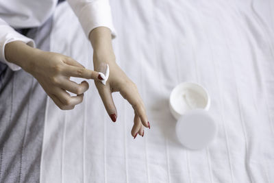 Beautiful groomed woman's hands with cream jar on blanket. moisturizing cream, soft skin. healthcare