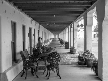 Empty chairs and tables in corridor of building