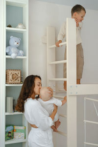 Children are playing on toddler indoor sports complex with mother