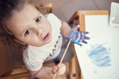 Children playing in an inner courtyard and painting with water paints