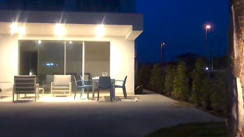 Empty chairs and tables in illuminated building at night