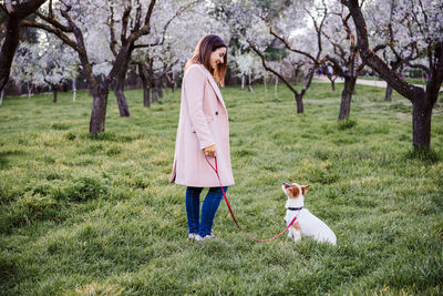 Side view of woman with dog on grass