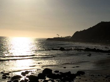 Scenic view of beach against sky during sunset