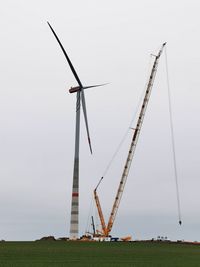 Windmill on field against sky