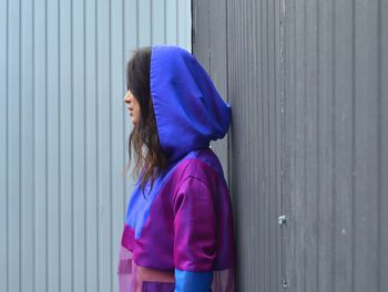 Girl standing against blue wall