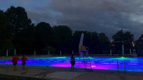 People by swimming pool at night