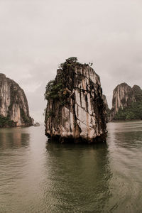 Rock formations in sea against sky