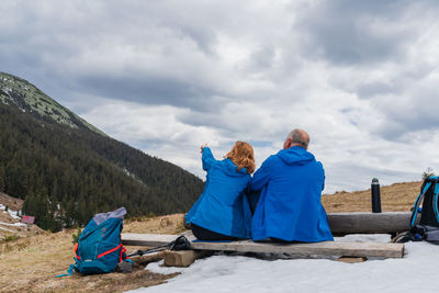 Rear view of people on mountain against sky