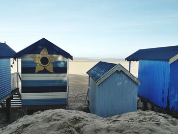 Built structure on beach by sea against sky