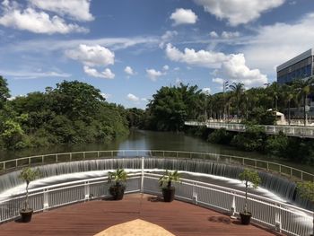 View of swimming pool by lake against sky