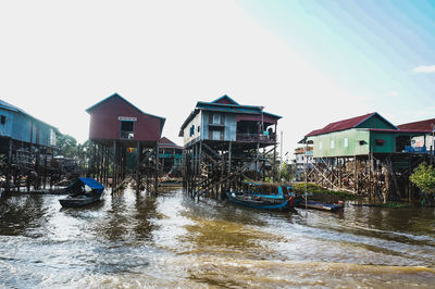 Buildings by river against sky