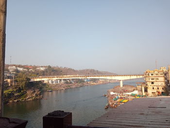 River amidst buildings in city against clear sky