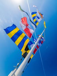 Low angle view of colorful flags against clear blue sky