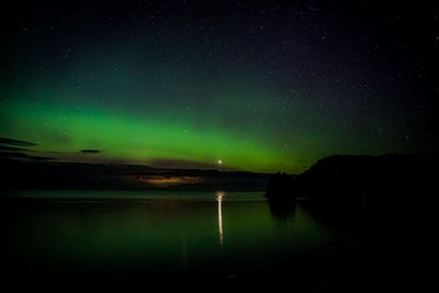 Scenic view of lake against sky at night