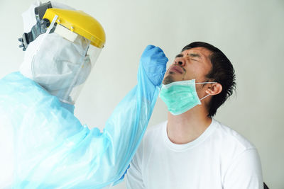 The doctors in the ppe protective suit performed a nasal swab corona test - corona virus / covid-19