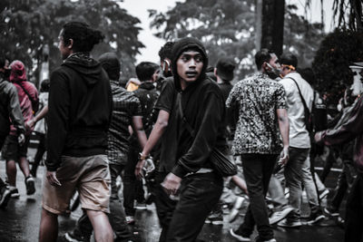 Rear view of people standing on street in city