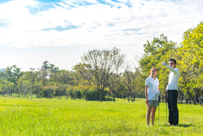 Full length of couple playing golf on field