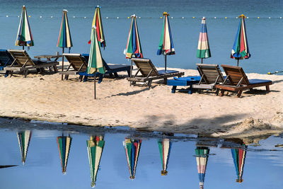 Chairs on beach against blue sky