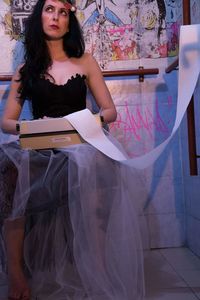 Full length of woman standing against wall