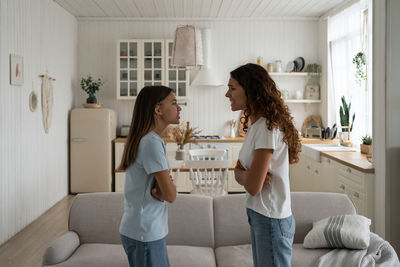 Side view of mother and daughter sitting at home