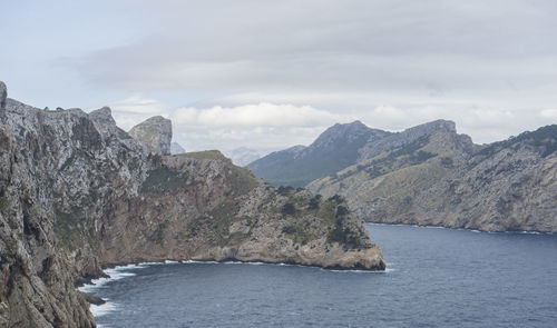 Scenic view of sea and mountains against sky